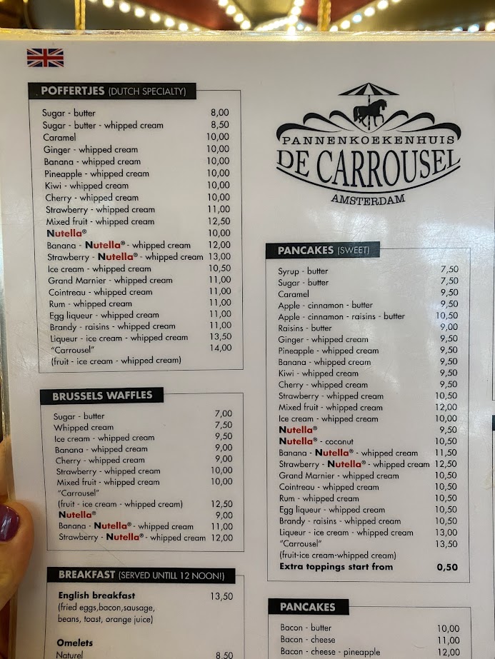 Menu from Pannenkoekenhuis De Carrousel in Amsterdam, featuring various Dutch specialties like poffertjes, pancakes, and Brussels waffles, with prices listed for each item.